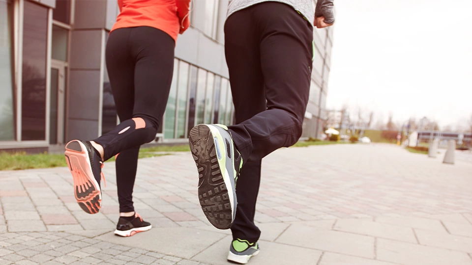 Atleta com deficiencia visual correndo com guia voluntario em prova de rua
